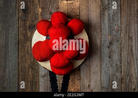 Black Forest cappello tradizionale appeso di fronte a legno rustico parete Foto Stock