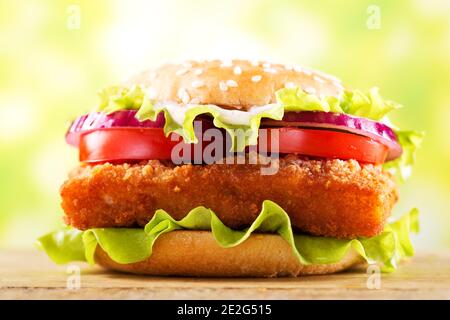hamburger di pesce con verdure su tavola di legno Foto Stock