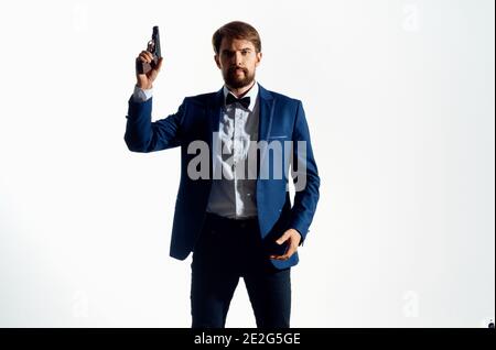 uomo in tuta tenendo pistola pericolo gangster omicidio sfondo isolato Foto Stock