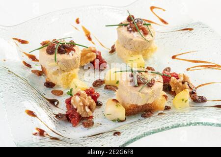 Foie con uvetta e noci e marmellata di pomodoro su un piastra bianca e sfondo Foto Stock