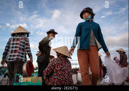 Uomini e donne che lavorano in un mercato del pesce sulla spiaggia, Mui NE, Vietnam Foto Stock