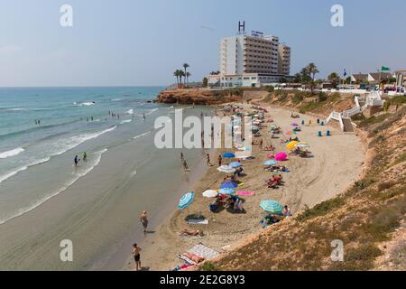 Playa Cala Cerrada Orihuela Spagna peoiple sulla spiaggia vicino a Los Angeles Zenia sotto il sole estivo Foto Stock