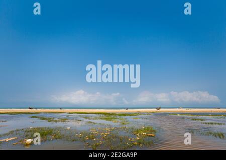 Bella spiaggia incontaminata Bien My Thuy in Hai An Vietnam. Hai Lang distretto, provincia di Quang Tri. Paesaggio con barche a vela locali, cielo blu durante il sole Foto Stock