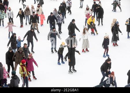 KIEV, UCRAINA - 03 gennaio 2021: Pattinaggio su ghiaccio persone. La gente si diverte nell'arena di ghiaccio della pista di pattinaggio della città. Vacanze di nuovo anno in città Kiev. Foto Stock