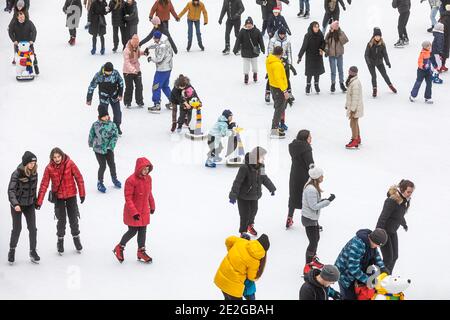 KIEV, UCRAINA - 03 gennaio 2021: Pattinaggio su ghiaccio persone. La gente si diverte nell'arena di ghiaccio della pista di pattinaggio della città. Vacanze di nuovo anno in città Kiev. Foto Stock