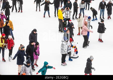 KIEV, UCRAINA - 03 gennaio 2021: Pattinaggio su ghiaccio persone. La gente si diverte nell'arena di ghiaccio della pista di pattinaggio della città. Vacanze di nuovo anno in città Kiev. Foto Stock