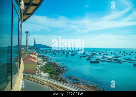 La più lunga funivia situata sull'isola di Phu Quoc Nel Vietnam del Sud e sotto sono fiancheggiate tradizionali barche di pescatori Nel porto della città di Duong Dong Foto Stock