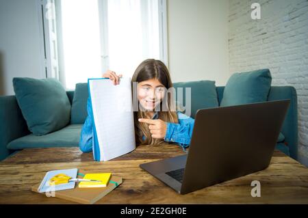 Felice ragazza teen sul laptop che studia online in remoto virtuale classe su internet a casa come la scuola superiore rimangono chiuso a causa dell'ultima chiusura del coronavirus Foto Stock