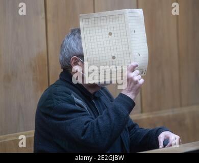 Hannover, Germania. 14 gennaio 2021. L'imputato si siede nel molo con una copertina di fronte al suo volto nella sala del tribunale distrettuale. All'inizio di un processo per omicidio, un uomo di 64 anni ha negato di aver adorato la sua fidanzata con spiriti metilati e di averla messa al fuoco. Ancora non sa perché ha bruciato, il convenuto ha avuto il suo avvocato di difesa spiegare nel tribunale regionale. Credit: Julian Stratenschulte/dpa/Alamy Live News Foto Stock