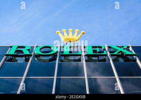 Vista dal basso del logo Rolex nella parte superiore di un edificio presso la sede del marchio svizzero di orologi di lusso a Ginevra. Foto Stock