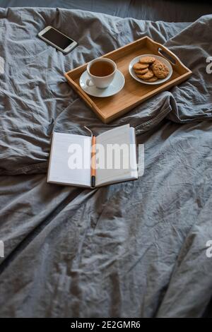 La prima colazione di tè e biscotti con un magazzino in un letto di grigio al mattino Foto Stock