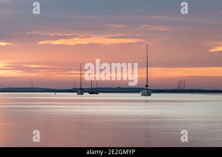 Barche sull'estuario della Swale a Kent al tramonto. Preso da Harty Ferry, Faversham. Foto Stock