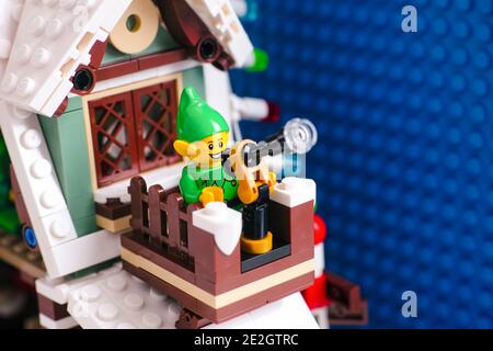 Tambov, Federazione Russa - 08 Gennaio 2021 la minifigura Lego Elf usa il telescopio sul tetto per seguire la slitta di Santa mentre decollerà nella sk notturna Foto Stock