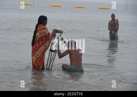 Kolkata, India. 14 gennaio 2021. Un uomo fisicamente disabile fa un tuffo alla confluenza di Gange e della Baia del Bengala durante il Gangasagar Mela in occasione di Makar Sankranti, un giorno considerato di grande significato religioso nella mitologia indù, a Sagar Island, a circa 150 km a sud di Kolkata. (Foto di Dipa Chakraborty/Pacific Press) Credit: Pacific Press Media Production Corp./Alamy Live News Foto Stock