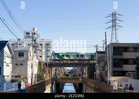 Un treno Tokyu Tamagawa Line serie 7000 su un ponte sopra il fiume Nomi vicino alla stazione di Ishikawa-dai Ota City, Tokyo, Giappone. Foto Stock