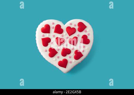 Torta cuore per San Valentino, Festa della mamma o compleanno, decorata con cuori di zucchero su sfondo blu Foto Stock