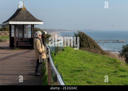 Una donna pensionata si affaccia sul mare dalla scogliera Top nella zona di East Cliff di Bournemouth spiaggia in L'inverno 28 novembre 2020 Neil Turner Foto Stock