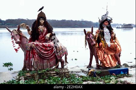 Chandannagar, Bengala Occidentale, India. Sulle rive del fiume Hooghly, parte del Gange, due statue di divinità induiste su cavalli. Foto Stock