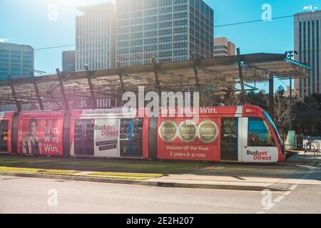 Adelaide City, South Australia - 13 agosto 2019: Tram moderno AdelaideMetro che attraversa Victoria Square in una giornata intensa Foto Stock