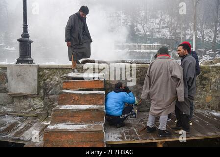 Srinagar, Kashmir. 14 gennaio 2021. Gli uomini siedono vicino ad un falò in una fredda mattina invernale a Srinagar.Night le temperature di mercoledì precipitarono ulteriormente attraverso la valle del Kashmir con il mercurio che si stabilì a meno 8.4°C a Srinagar, la temperatura più bassa di questa stagione finora e la più fredda notte di gennaio negli ultimi 25 anni, ha detto i funzionari il giovedì. Credit: SOPA Images Limited/Alamy Live News Foto Stock