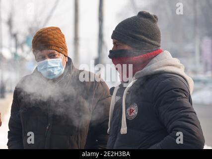 Srinagar, Kashmir. 14 gennaio 2021. Gli uomini del Kashmiri parlano sulla riva del lago dal durante una fredda mattina invernale a Srinagar.Notte le temperature del mercoledì sono precipitati ulteriormente attraverso la valle del Kashmir con il mercurio che si stabiliva a meno 8.4°C a Srinagar, la temperatura più bassa di questa stagione finora e la notte di gennaio più fredda negli ultimi 25 anni, I funzionari hanno detto giovedì. Credit: SOPA Images Limited/Alamy Live News Foto Stock