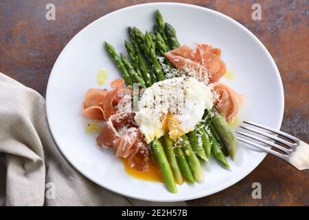 Uova Benedetto con parmigiano, asparagi verdi e prosciutto di Parma Foto Stock