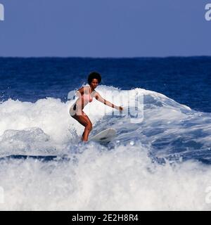 Bella giovane donna sta imparando a stare in piedi su una tavola da surf. Scuola di surf. Sport acquatici, Oceano Atlantico Repubblica Dominicana. 29.12.2016. Foto Stock