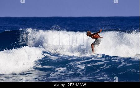 Scuola di surfista. Un ragazzo giovane imparando a stare in piedi su una tavola da surf. Surfista sull'onda, bellissima onda sull'oceano. Sport acquatici. Oceano Atlantico, Domenicano Foto Stock