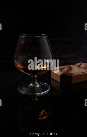 Brandy, Cognac, in Brandy Balloon, vetro di cristallo vintage con un sigaro Havan in un posacenere di legno fatto dal topo uomo. Foto Stock