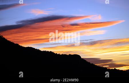 Tramonto sulle montagne. Intervallo di tempo del sole che tramonta sulle montagne. Sequenza di nuvole che si formano e si dissipano vicino al tramonto passando per sopra il cielo dentro Foto Stock