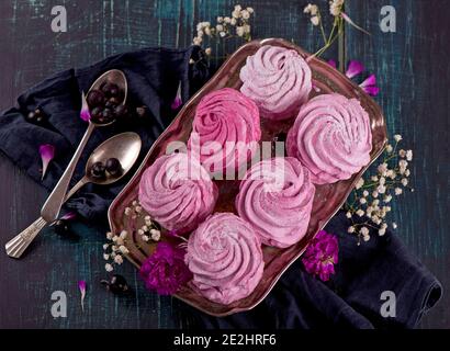 zephyr, marshmallow rosa, giace su un tavolo di legno. Vista dall'alto Foto Stock