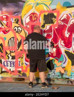 HELSINGBORG, SVEZIA - 08 AGOSTO 2020: Un uomo adulto crea un po' di graffiti nel parco di pattinaggio pixlapiren della città. Foto Stock