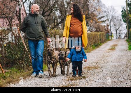 La famiglia sta prendendo un cane per una passeggiata e godendosi attività all'aperto Foto Stock