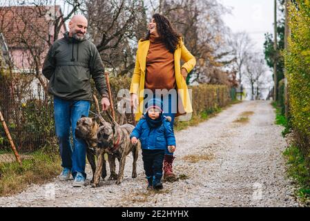 La famiglia sta prendendo un cane per una passeggiata e godendosi attività all'aperto Foto Stock