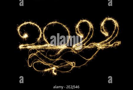 Felice anno nuovo 2022. Disegno di notte con sparklers. Numeri 2022. Lunga esposizione nella foto. La magia delle vacanze di Natale di Capodanno. Congratulati Foto Stock