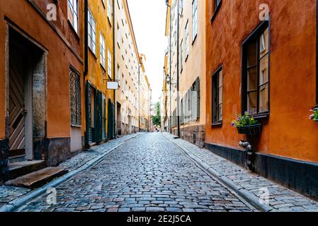 Bella vecchia strada acciottolata tra vecchie case colorate a Gamla Stan Quarter a Stoccolma Foto Stock