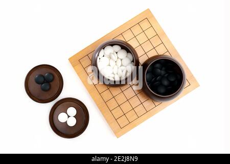 Goban, Baduk, Weiqi o Maklom - gioco da tavolo di strategia asiatica tradizionale. Pietra bianca e nera del gioco da tavolo cinese Foto Stock