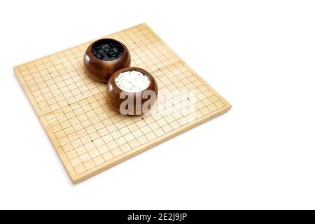 Goban, Baduk, Weiqi o Maklom - gioco da tavolo di strategia asiatica tradizionale. Pietra bianca e nera del gioco da tavolo cinese Foto Stock