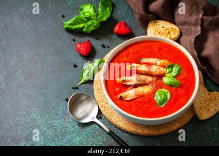 Zuppa fredda tradizionale gazpacho fatta in casa. Zuppa di pomodoro purea gazpacho con pomodori serviti frutti di mare su uno sfondo di pietra. Spazio di copia. Foto Stock