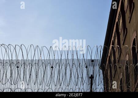 Filo spinato su un muro in una prigione Foto Stock