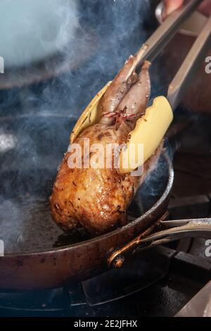 Cocker spaniel orologi chef Neil Churchill preparare un gallo morto sulla piuma, Londra, Inghilterra, Regno Unito Foto Stock