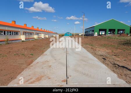 Magazzino Hangar. Costruzione di hangar da un telaio metallico e moderno materiale da parete da pannelli sandwich. Edifici prefabbricati da telaio e padella Foto Stock