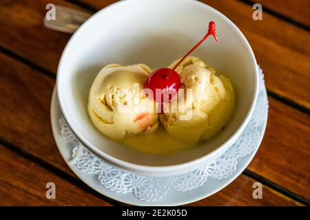 Il ristorante Aquarium sulla spiaggia di Magazine a Calliste, Grenada, serve due palline di gelato pallido e cremoso ricoperte da una ciliegia maraschino. Foto Stock