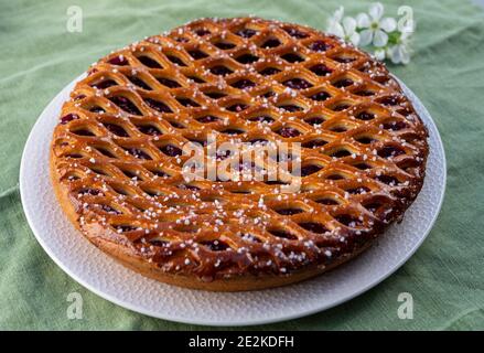 Torta di ciliegie con graticcio di Limburgo, Olanda, servita in giardino soleggiato Foto Stock
