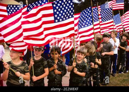 GRUPPO DI RAGAZZI PATRIOTTICI DEGLI ANNI OTTANTA CHE INDOSSANO T-SHIRT CON MOTIVO CAMOUFLAGE BANDIERE AMERICANE CHE PARTECIPANO ALLA PARATA NAZIONALE DI CELEBRAZIONE - CJ001540 CAM001 HARS NORD AMERICA LIBERTÀ NORD AMERICA ALLEGRO CAMUFFAMENTO AVVENTURA AD ANGOLO ALTO DIVERTIMENTO RICREAZIONE CAM001 ORGOGLIO DI PATRIOT BOY SCOUT THRIFTY CORTESE LE T-SHIRT SONO CORDIALI E DISPONIBILI, GENTILI E PATRIOTICHE, RISPETTOSE STELLE E STRISCE PARTECIPAZIONE ALLA COOPERAZIONE CRESCITA GIOVANI PATRIOTTISMO LEALE ROSSO BIANCO E BLU TRUPPA DI TOGETHERNESS ESSERE PREPARATI CORAGGIOSO ETNIA CAUCASICA OBBEDIENTE VECCHIO STILE Foto Stock