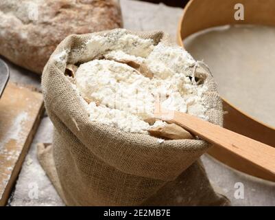 farina di grano bianco in un piccolo sacco di burlap, primo piano Foto Stock