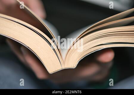 Uomo primo piano durante la lettura del libro nel tempo libero, studio di conoscenza in lock down, stile di vita di relax a casa Foto Stock
