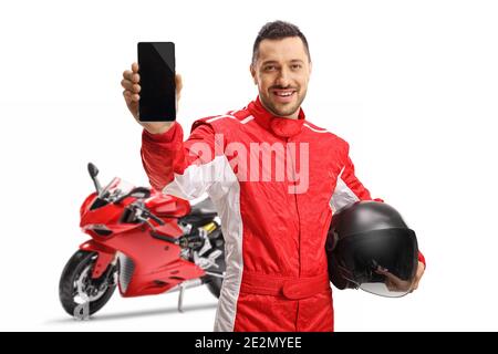 Moto racer in un jumpsuit che mostra un telefono cellulare e. tenendo un casco isolato su sfondo bianco Foto Stock