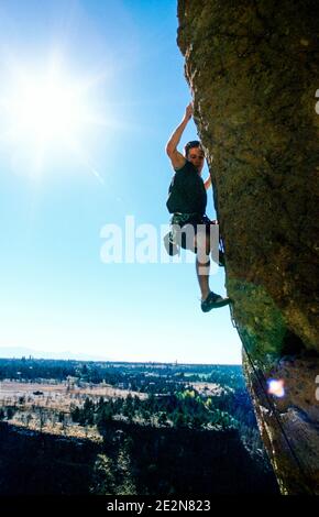 Un arrampicatore maschile su una scogliera a strapiombo sullo Smith Rock state Park, Oregon, USA. Foto Stock