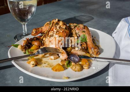 Vista sopra di un piatto di pollo arrosto mangiato a metà e. patate Foto Stock
